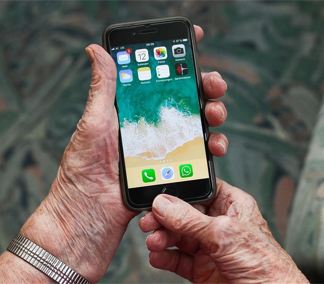 Hände einer älteren Person mit Smartphone